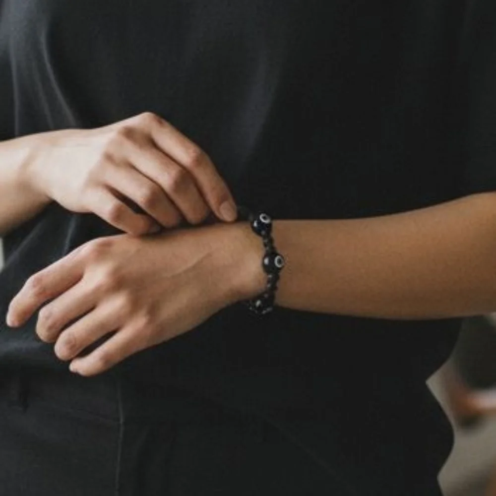 Black beaded bracelet featuring eight 8-ball